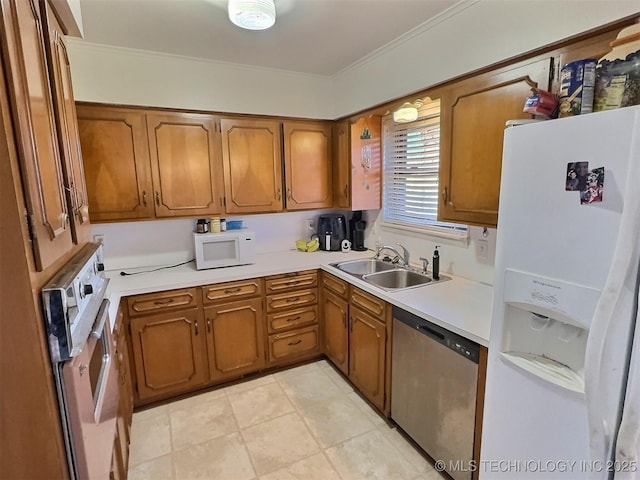 kitchen with white appliances, brown cabinetry, and a sink