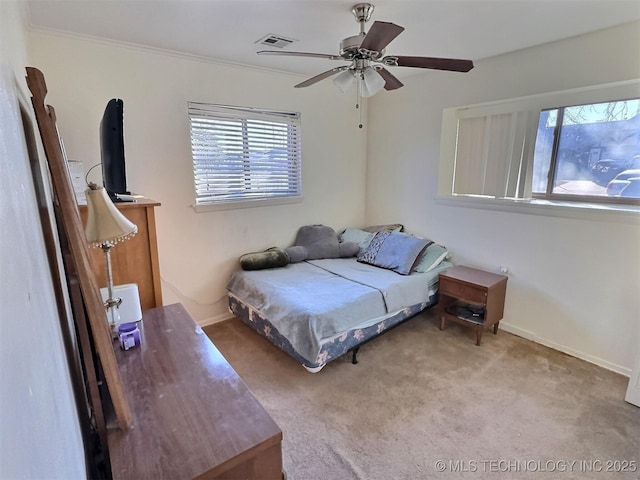 carpeted bedroom with a ceiling fan, visible vents, baseboards, and multiple windows