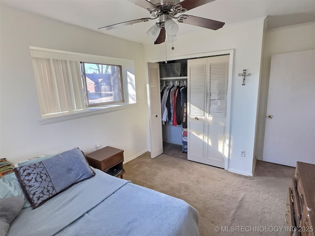 carpeted bedroom with ceiling fan, baseboards, and a closet