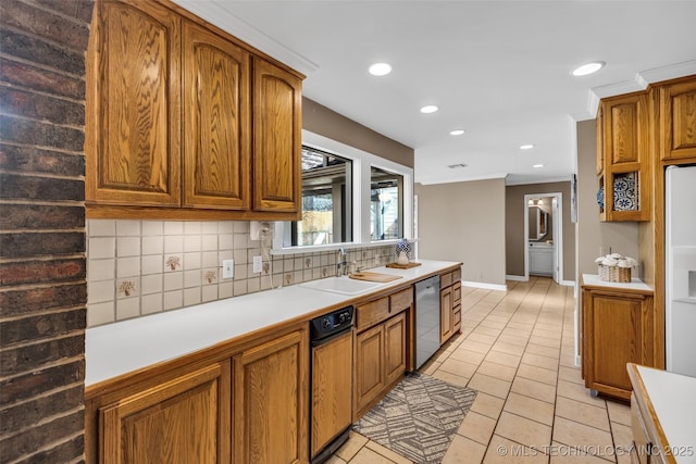 kitchen with tasteful backsplash, dishwasher, brown cabinets, light countertops, and a sink