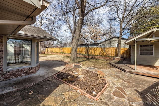 view of yard featuring fence, a deck, and a patio