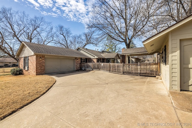 view of side of property featuring an attached garage, roof with shingles, concrete driveway, and brick siding