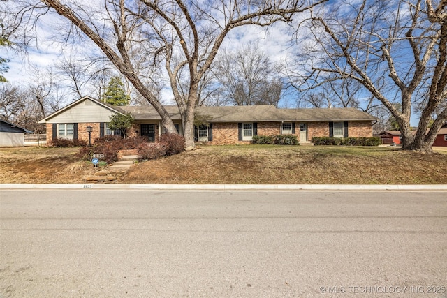 ranch-style house featuring brick siding