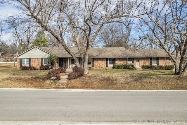 ranch-style home with a front yard and brick siding