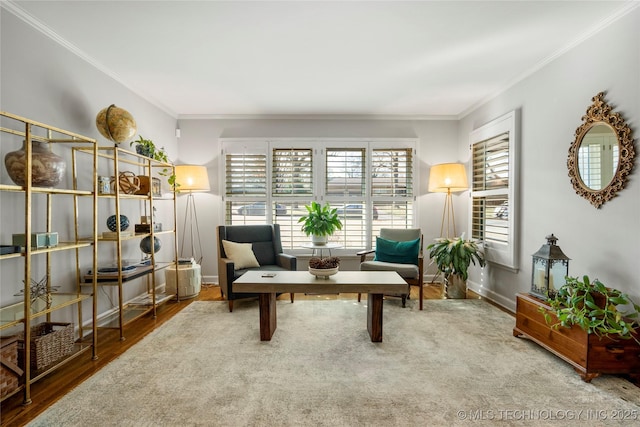 sitting room featuring ornamental molding, baseboards, and wood finished floors