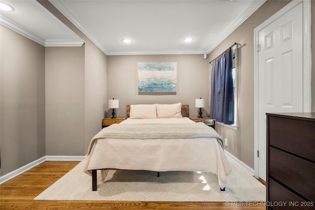 bedroom featuring ornamental molding, wood finished floors, and baseboards