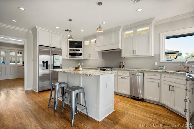 kitchen with light wood-style floors, stainless steel fridge, crown molding, and white cabinetry