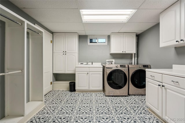 laundry area with cabinet space, a sink, and washing machine and clothes dryer