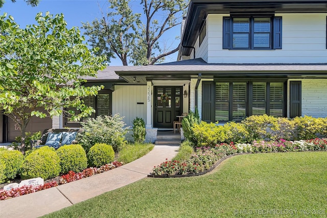 property entrance featuring a garage, a shingled roof, and a lawn