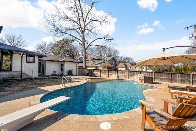 view of swimming pool featuring a diving board, a patio, a fenced backyard, and a fenced in pool