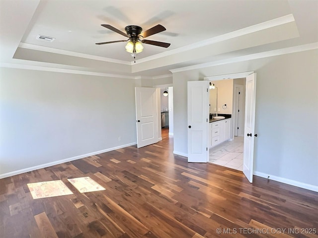 unfurnished bedroom featuring baseboards, visible vents, a raised ceiling, and ornamental molding