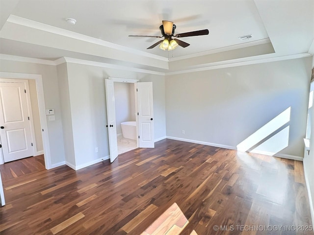 unfurnished room featuring baseboards, a tray ceiling, dark wood-type flooring, and ornamental molding