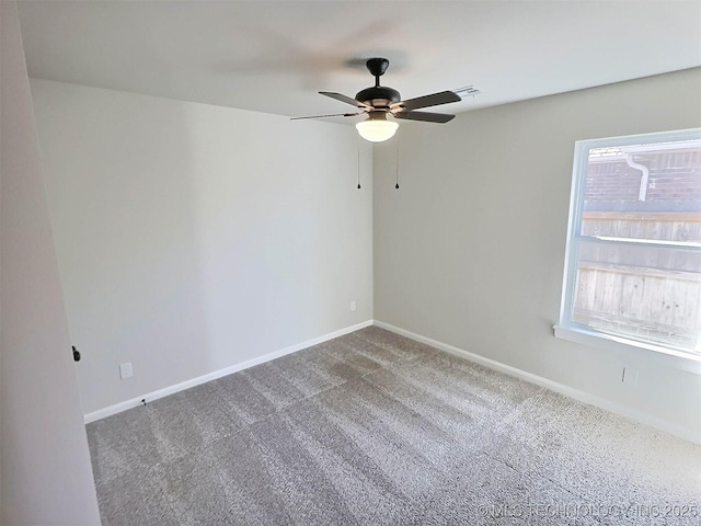 spare room with carpet floors, visible vents, baseboards, and a ceiling fan