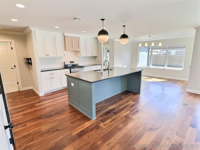 kitchen featuring a sink, visible vents, white cabinetry, ornamental molding, and gas range