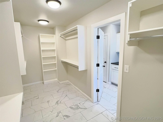 walk in closet with marble finish floor