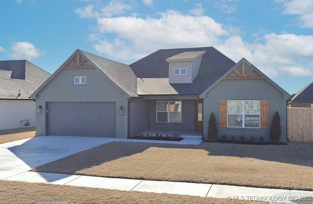 view of front of property with concrete driveway, fence, and an attached garage