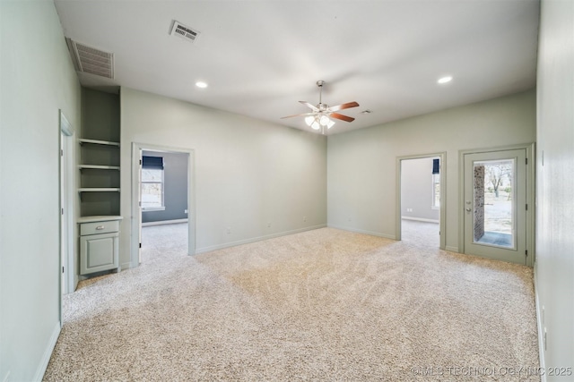 carpeted empty room featuring baseboards, a ceiling fan, visible vents, and recessed lighting