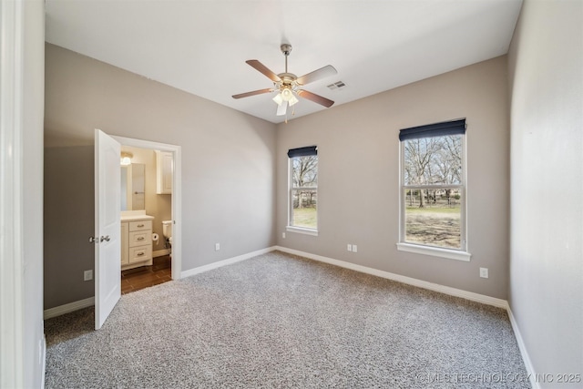 unfurnished bedroom with visible vents, baseboards, a ceiling fan, ensuite bathroom, and carpet floors