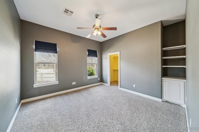 unfurnished bedroom with baseboards, visible vents, a ceiling fan, a spacious closet, and carpet floors