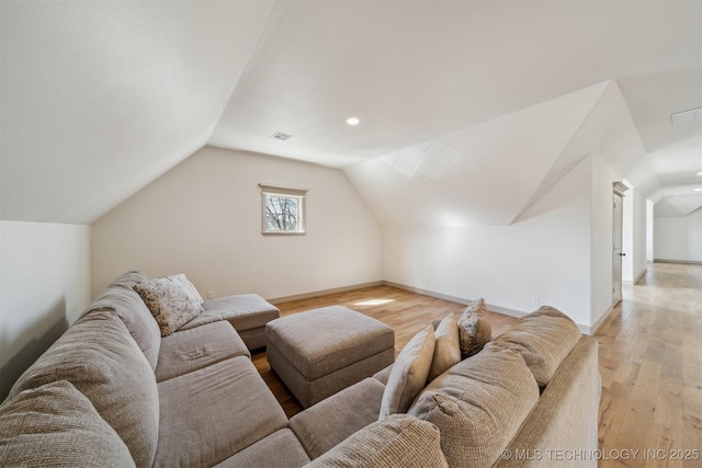 living room with lofted ceiling, visible vents, light wood-style flooring, and baseboards