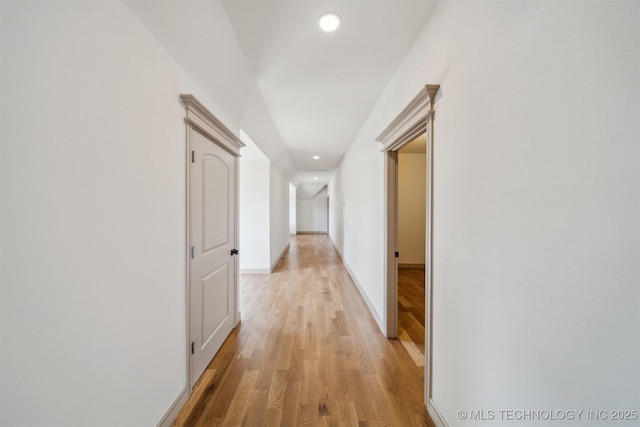 hall with light wood-style flooring, baseboards, and recessed lighting