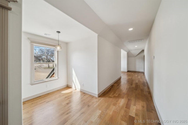 hall featuring light wood-type flooring, visible vents, baseboards, and recessed lighting