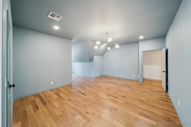 unfurnished room featuring baseboards, light wood-type flooring, visible vents, and a notable chandelier