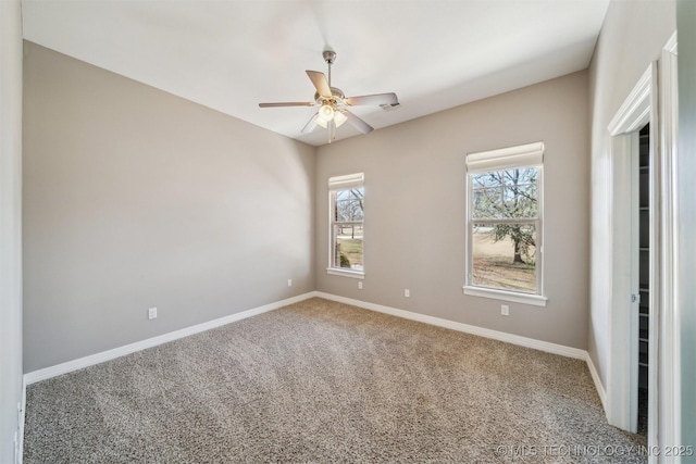 empty room featuring carpet flooring, a ceiling fan, and baseboards