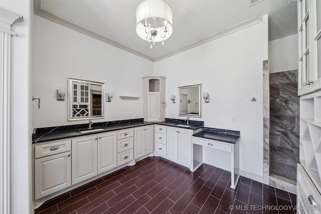 kitchen with a chandelier, dark countertops, a sink, and wood tiled floor