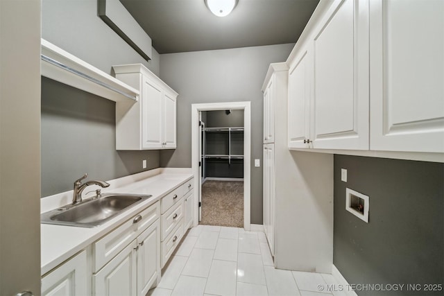 clothes washing area featuring cabinet space, light tile patterned floors, baseboards, hookup for a washing machine, and a sink