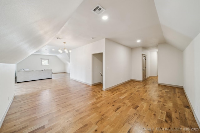 additional living space with baseboards, visible vents, lofted ceiling, light wood-style floors, and recessed lighting