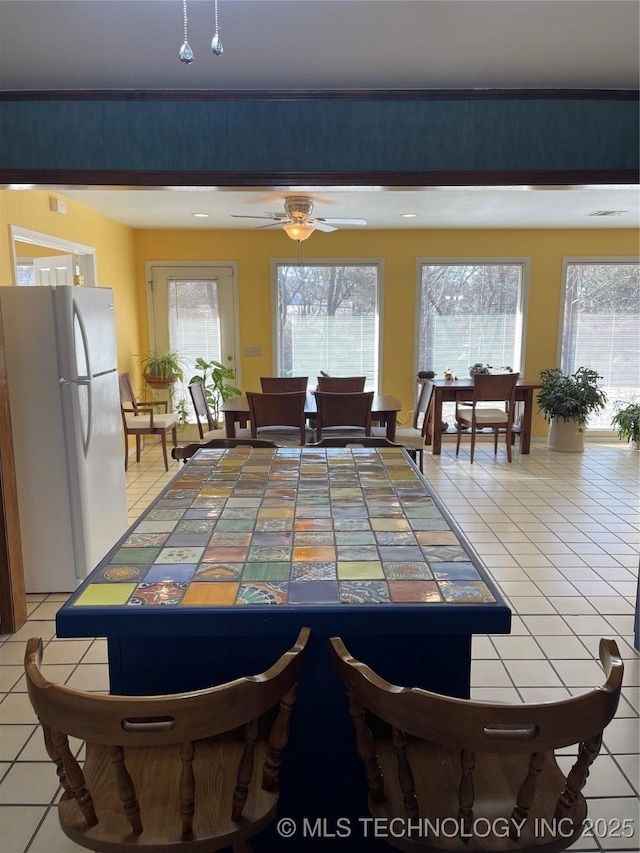 dining room featuring light tile patterned floors and a ceiling fan