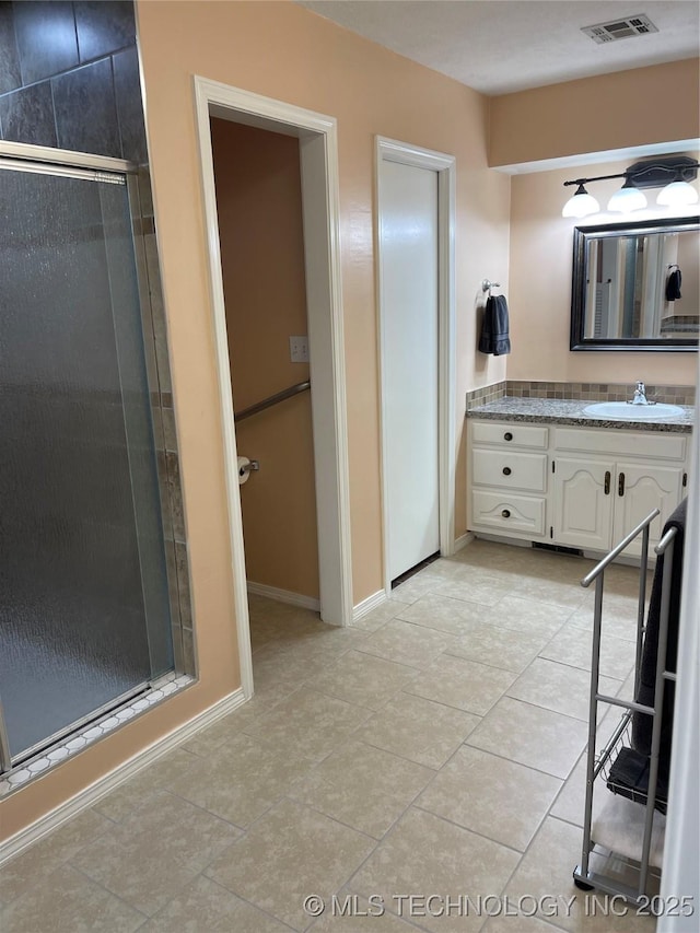 full bath featuring visible vents, baseboards, tile patterned floors, vanity, and a shower stall