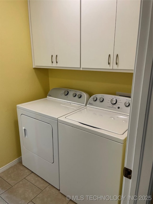 washroom featuring cabinet space, light tile patterned floors, baseboards, and washer and dryer