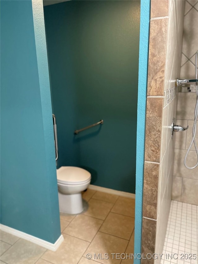 full bath with baseboards, tiled shower, toilet, and tile patterned floors