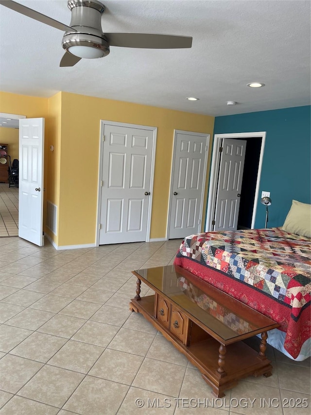 bedroom with baseboards, visible vents, a textured ceiling, and light tile patterned flooring