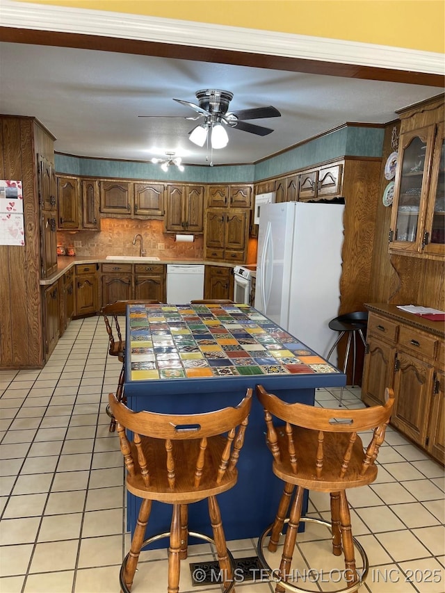 dining space featuring ceiling fan, ornamental molding, and light tile patterned flooring