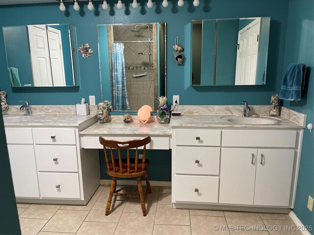 full bathroom with tile patterned flooring, tiled shower, and vanity