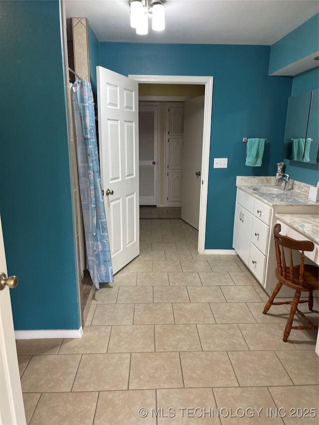 full bath featuring a shower with shower curtain, tile patterned floors, baseboards, and vanity