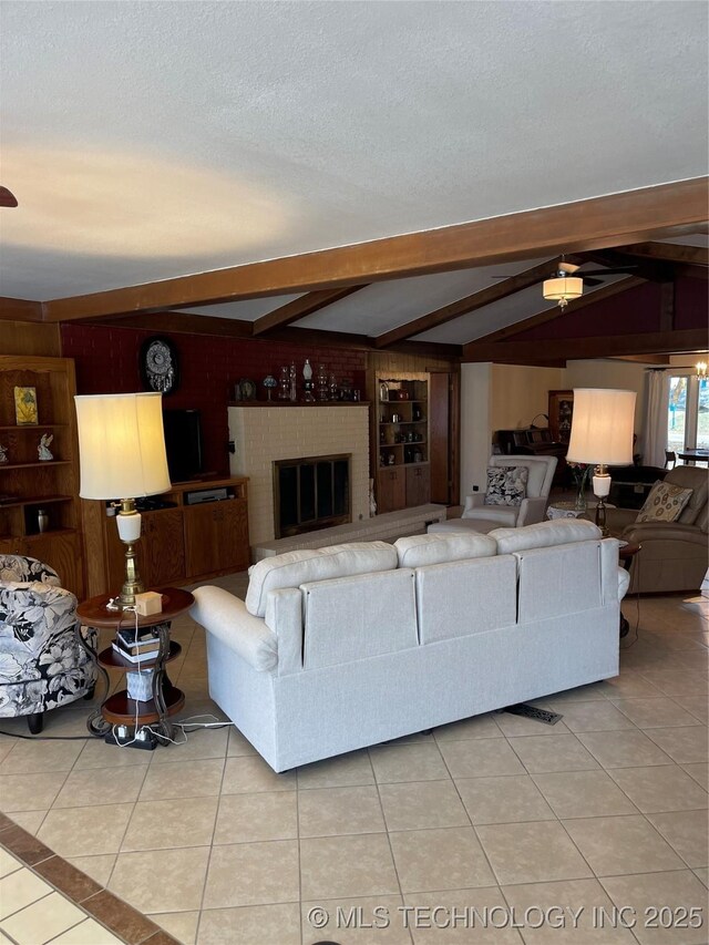 living area featuring lofted ceiling with beams, light tile patterned floors, a textured ceiling, and wooden walls