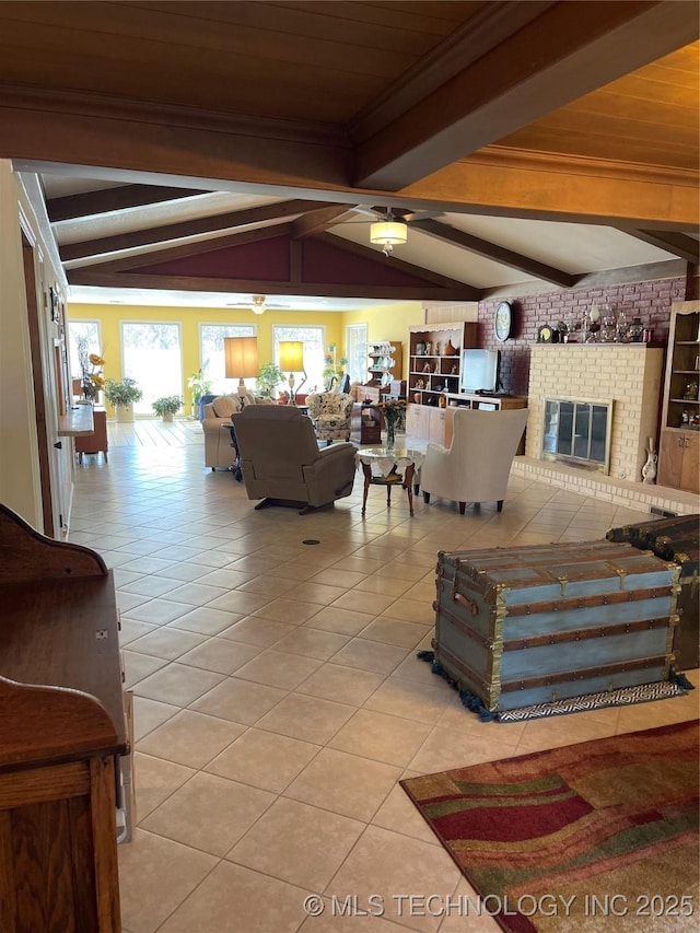 living area featuring vaulted ceiling with beams, a fireplace, and light tile patterned flooring