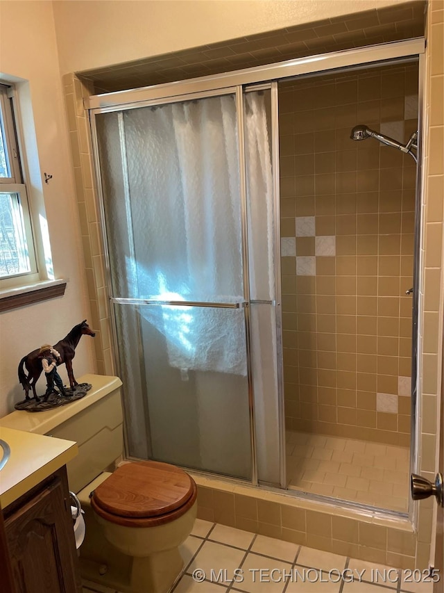 bathroom featuring toilet, tile patterned flooring, a shower stall, and vanity