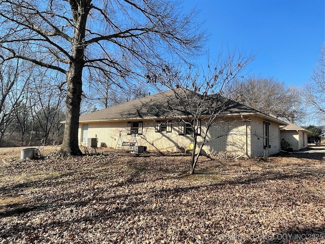 rear view of property featuring brick siding and cooling unit