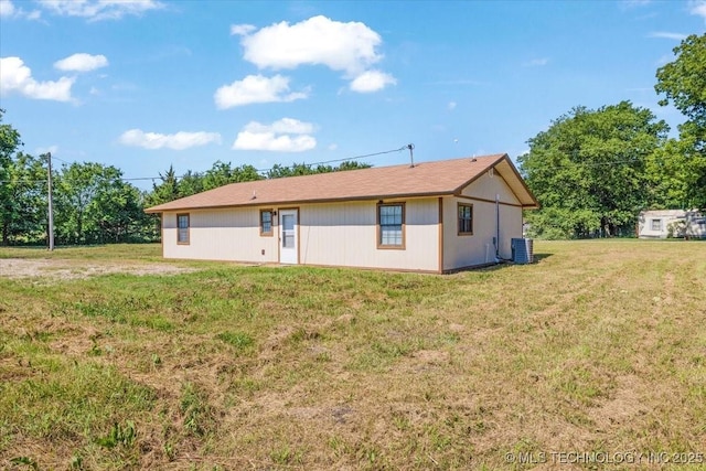 back of property featuring a yard and central AC unit