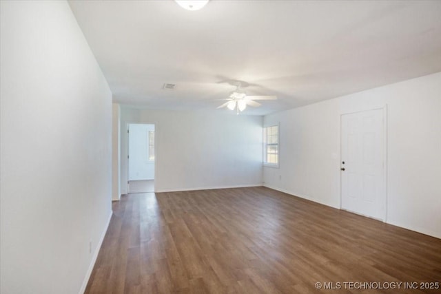 unfurnished room with ceiling fan, wood finished floors, and baseboards