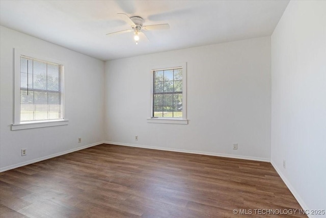 unfurnished room featuring ceiling fan, baseboards, and dark wood finished floors