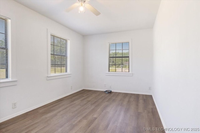 empty room featuring ceiling fan, baseboards, and wood finished floors