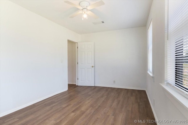 spare room featuring ceiling fan, baseboards, and wood finished floors