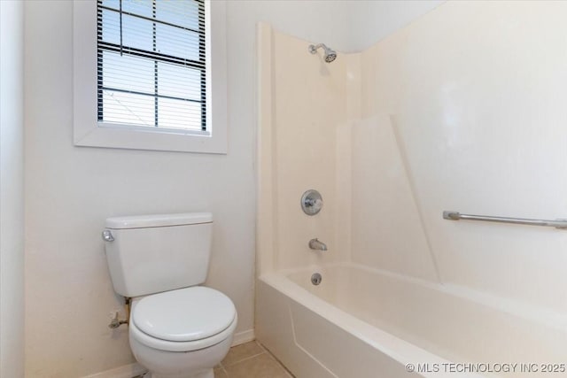 bathroom with bathing tub / shower combination, tile patterned flooring, toilet, and baseboards