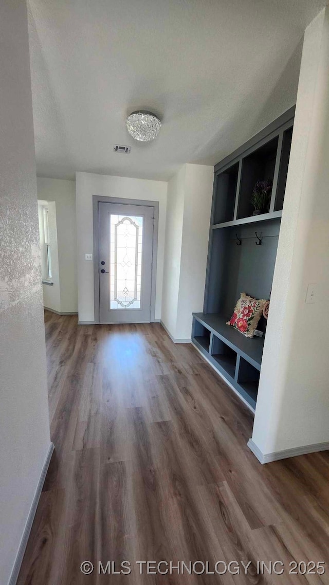 mudroom featuring wood finished floors, visible vents, and baseboards